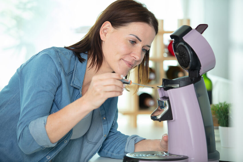 woman repairing a household coffee machine